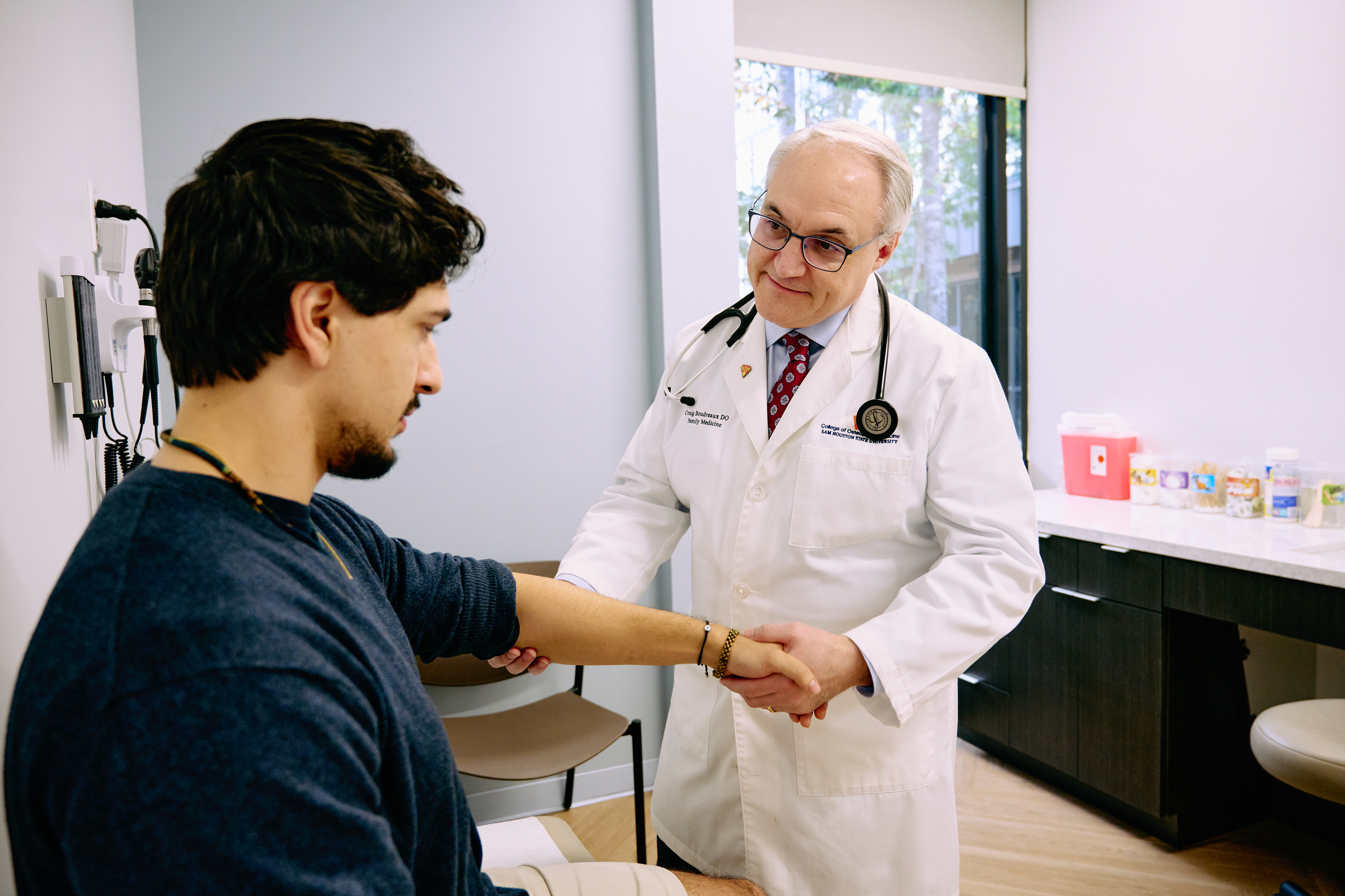 Doctor examines a patient’s arm during a visit at SHSU Physicians.