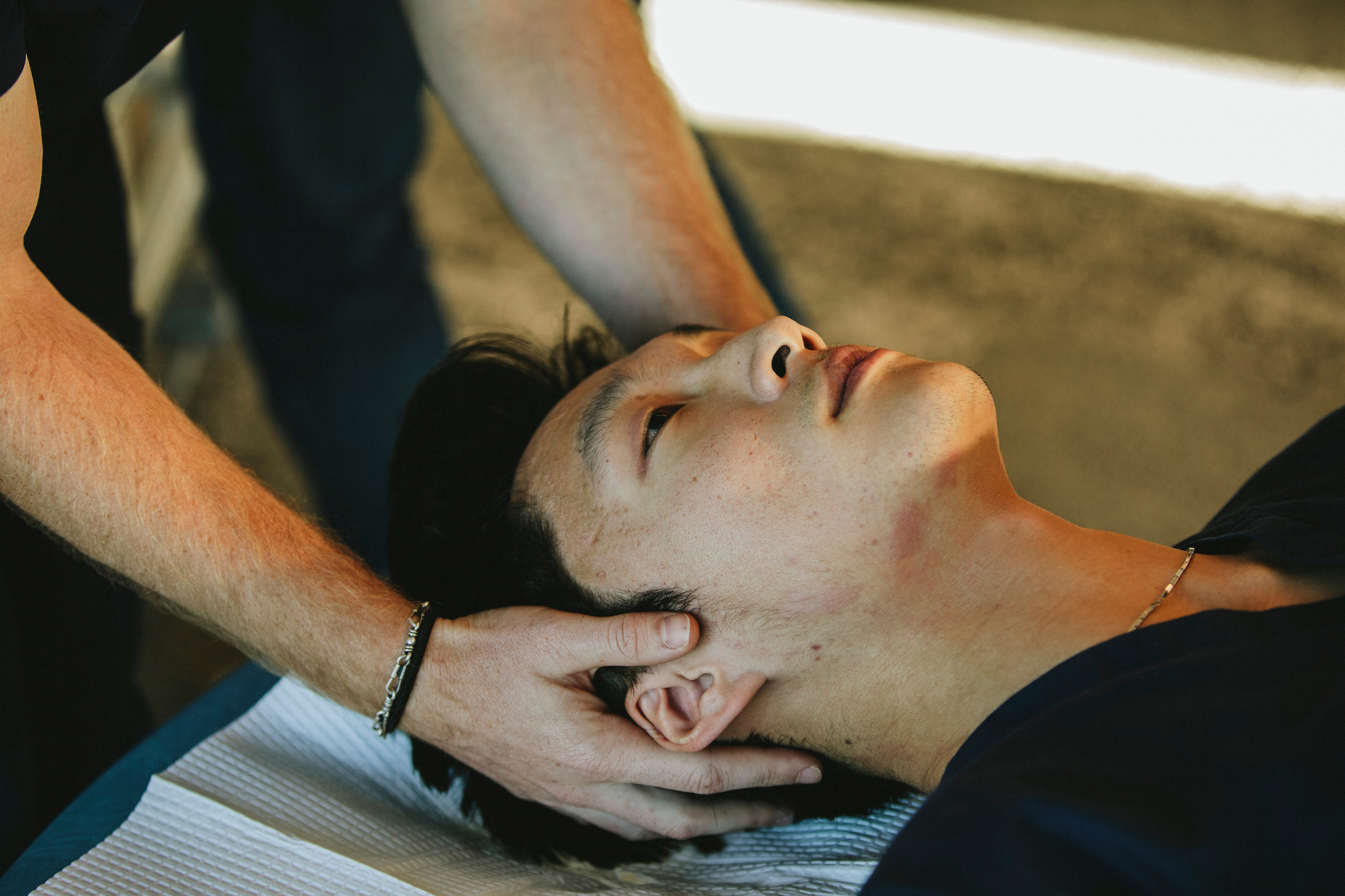 A provider gently supports a patient's head during an osteopathic manipulative treatment session at SHSU Physicians.