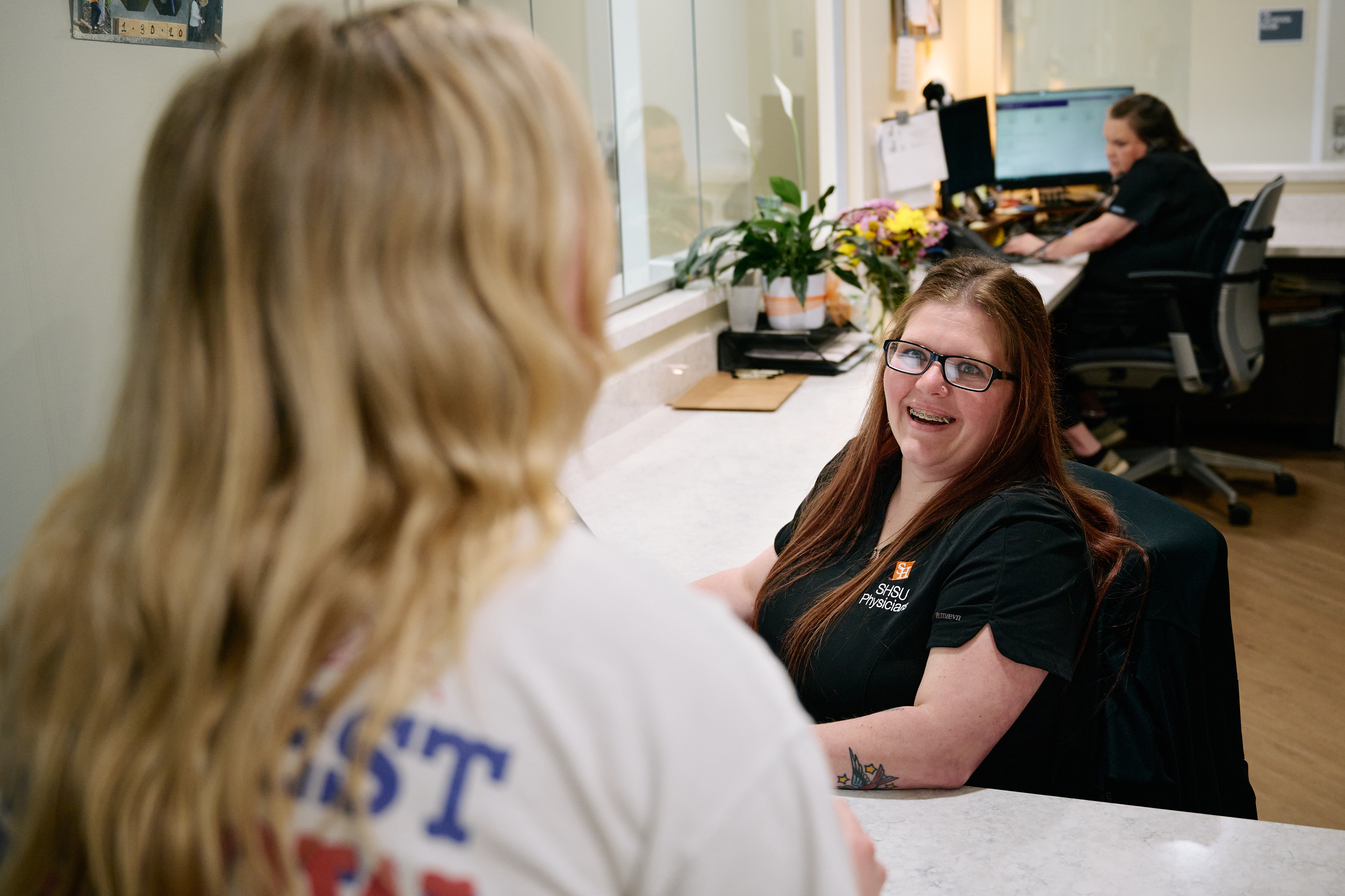 Receptionist checking patient out at front desk